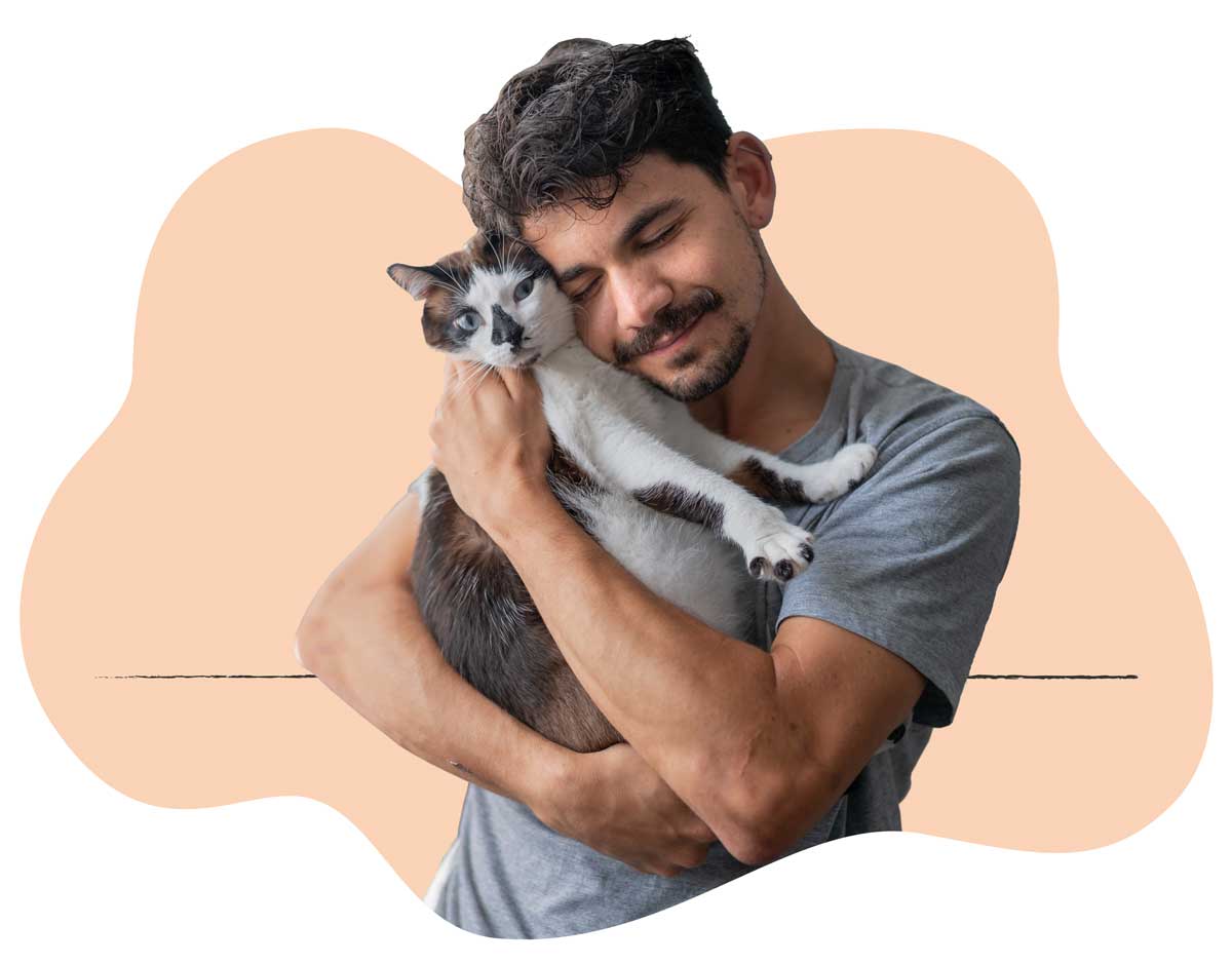 A man in a gray shirt holding his white and brown cat