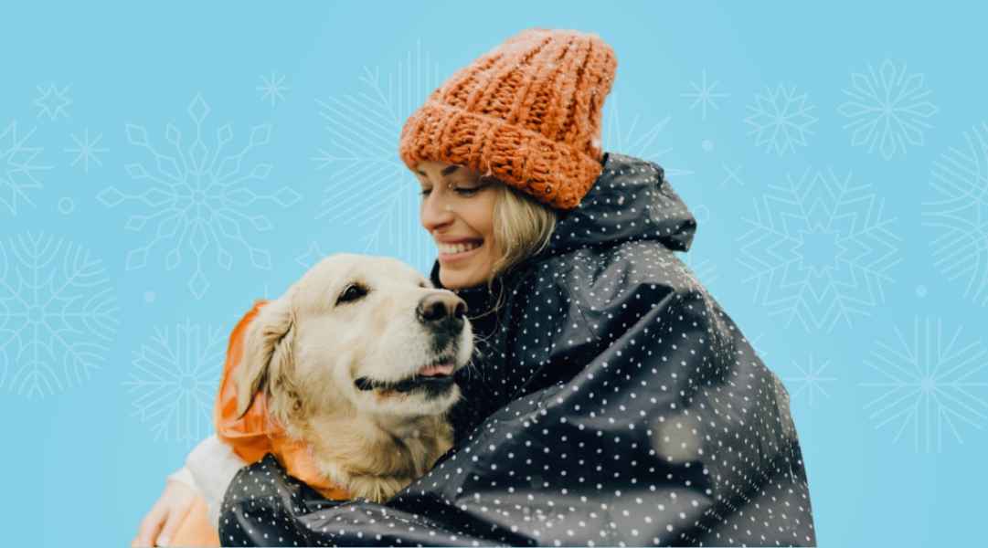 A woman holding a happy Golden Retriever